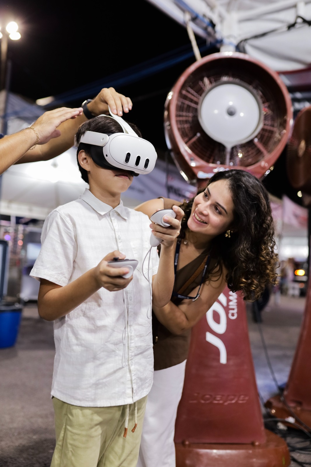 Criança experimentando óculos de realidade virtual em stand da feira